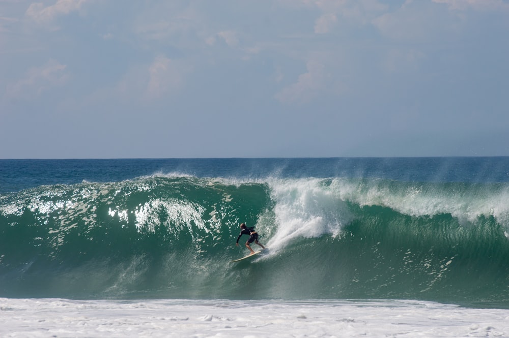 a man riding a wave on top of a surfboard