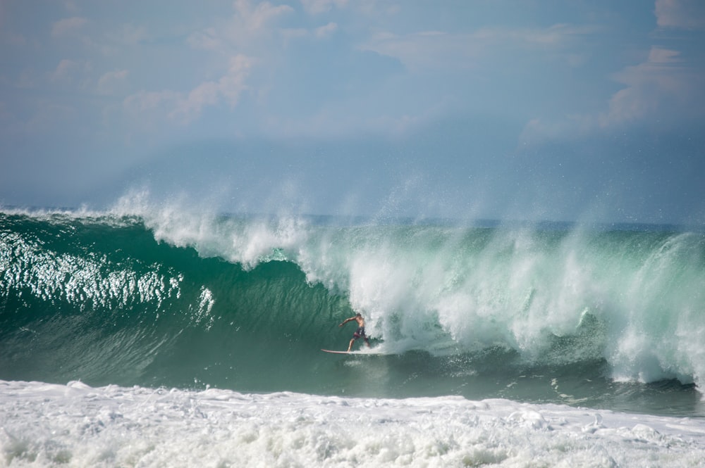 a man riding a wave on top of a surfboard