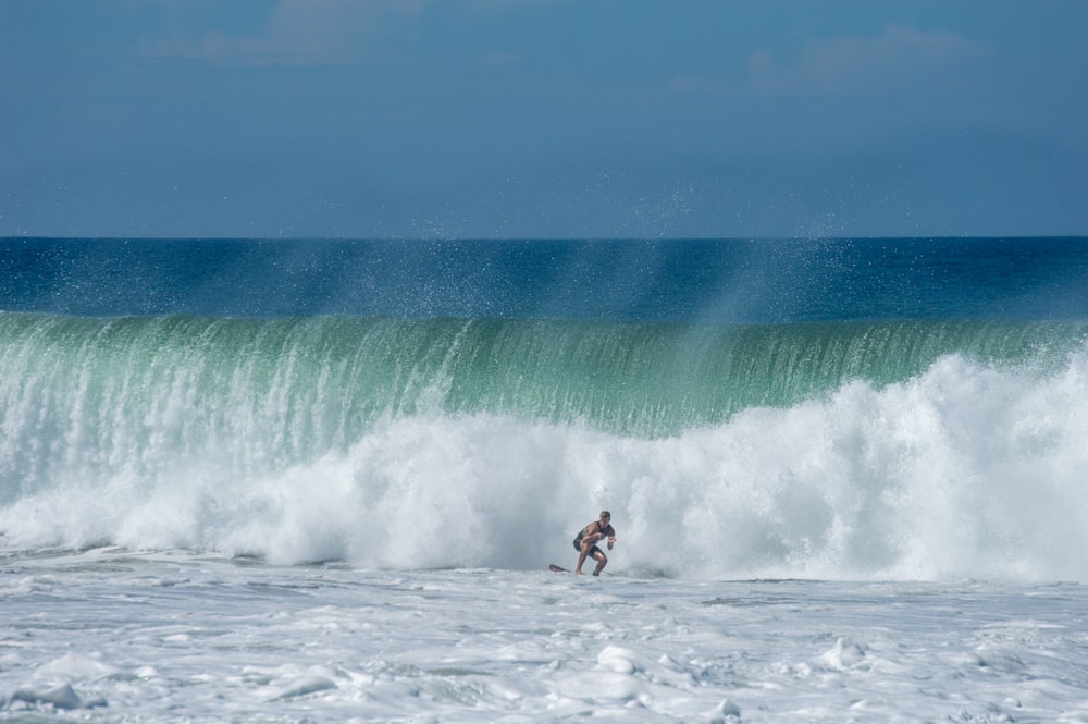 Un uomo che cavalca un'onda in cima a una tavola da surf