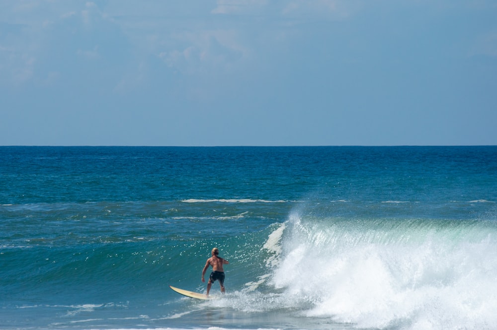 Un uomo che cavalca un'onda in cima a una tavola da surf