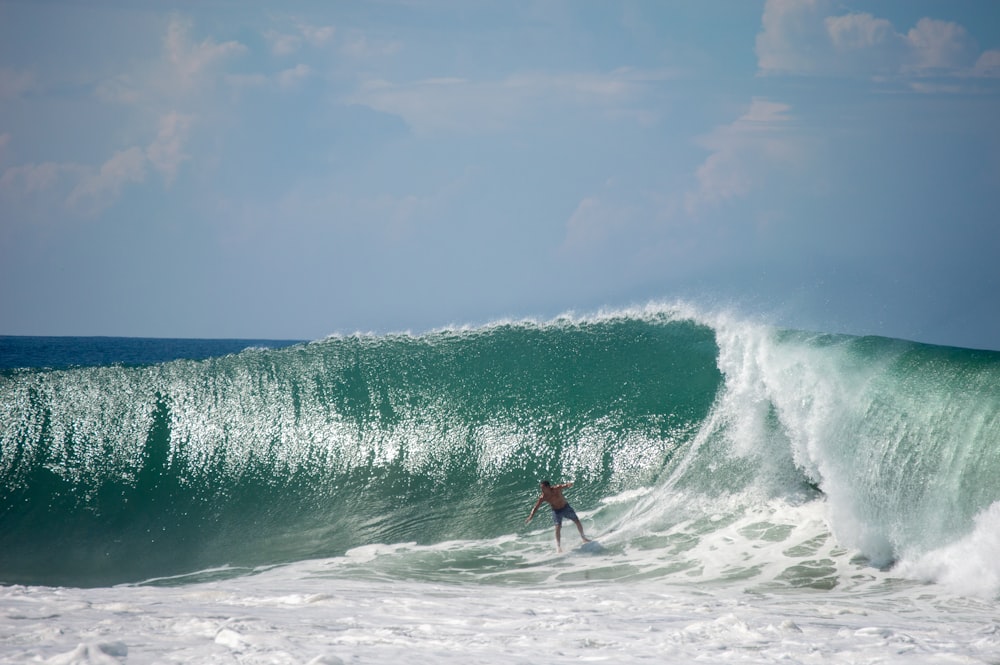 Ein Mann reitet auf einer Welle auf einem Surfbrett