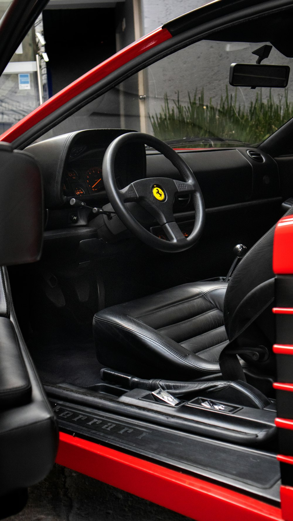 the interior of a red car with black leather seats