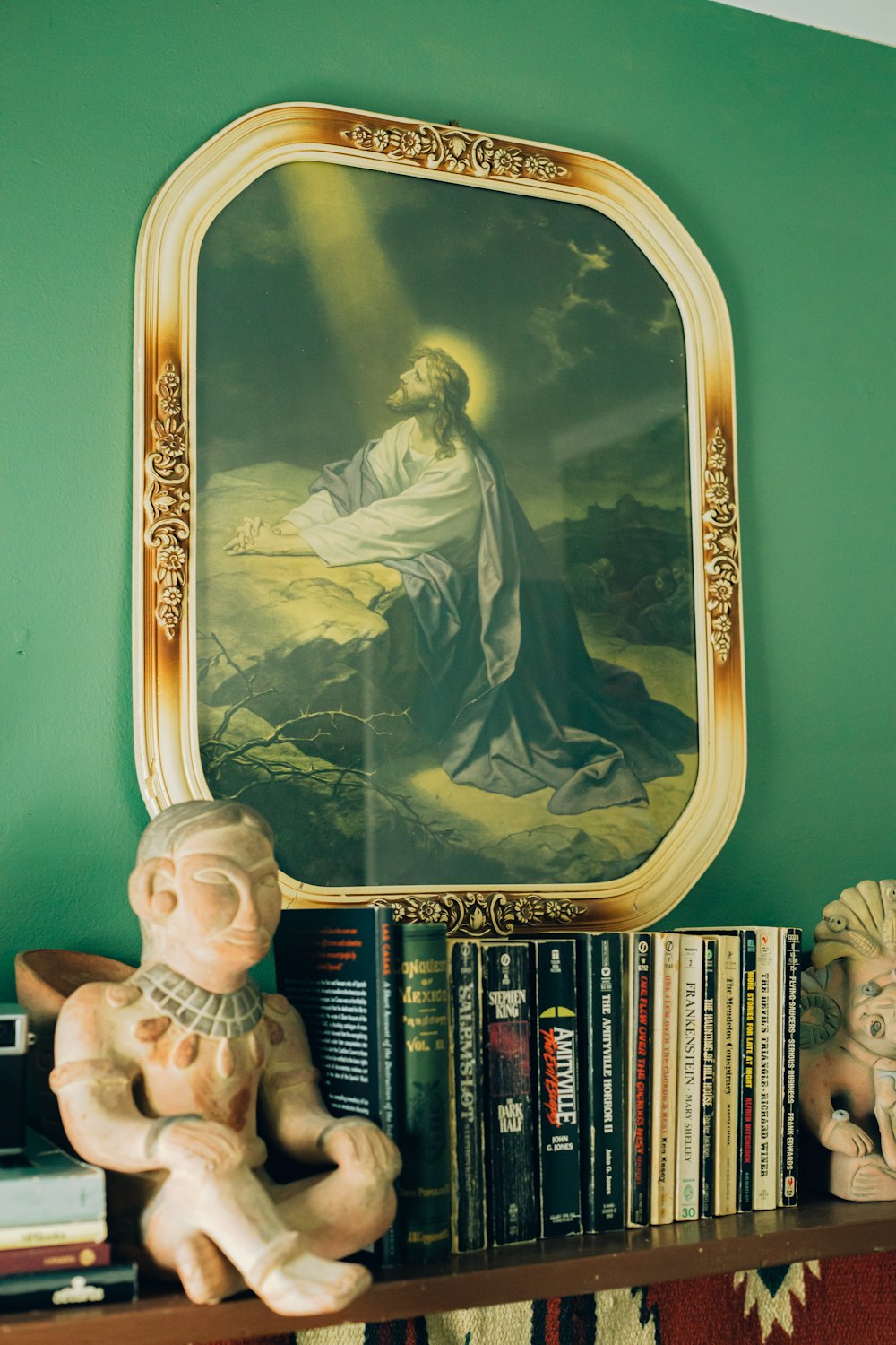 a shelf with a statue and a painting on it