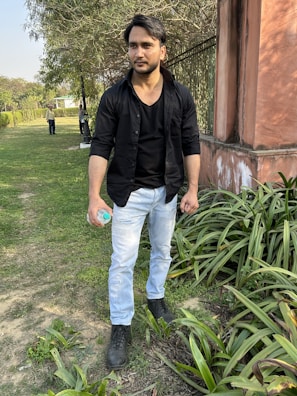 A man jogging in a park wearing black athletic wear, holding a USA Biotics water bottle.