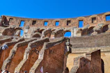 Historic Roman Colosseum under a bright blue sky showcasing ancient architecture and tourists exploring