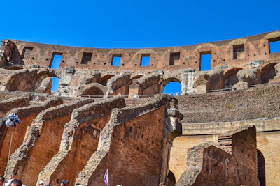 Historic Roman Colosseum under a bright blue sky showcasing ancient architecture and tourists exploring