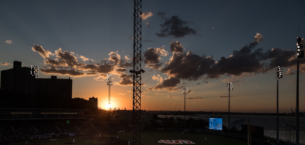 the sun is setting over a baseball field