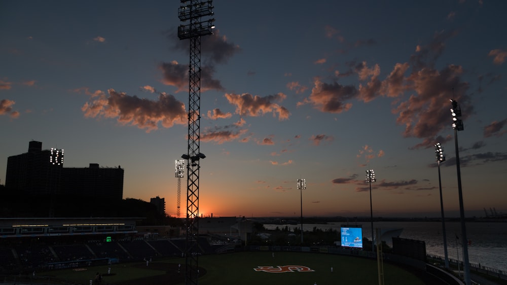 a baseball field with a sunset in the background