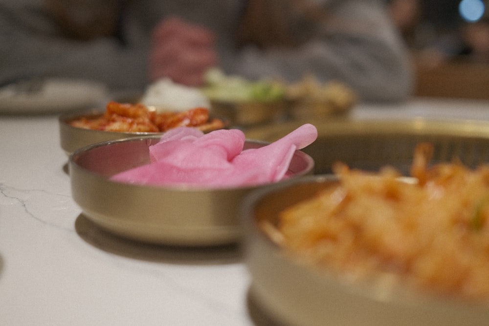 a table topped with metal containers filled with food