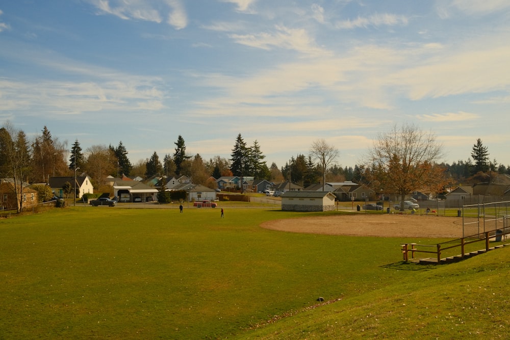 a baseball field with a wooden bench in the middle of it