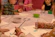 Children gathered around a table, painting and crafting with joyful expressions in a vibrant studio.