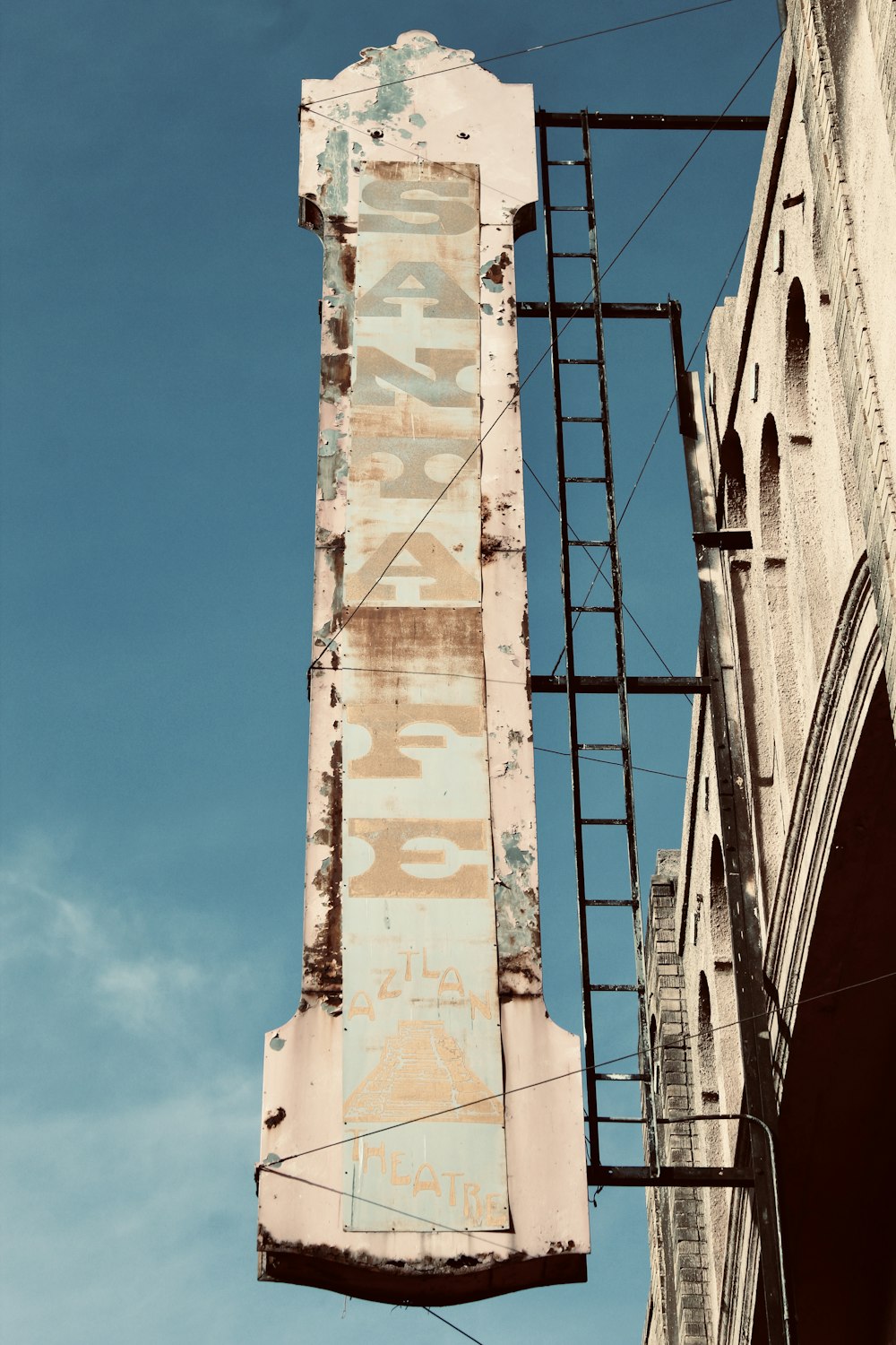 an old sign hanging off the side of a building
