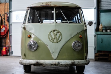 a green and white vw bus parked in a garage