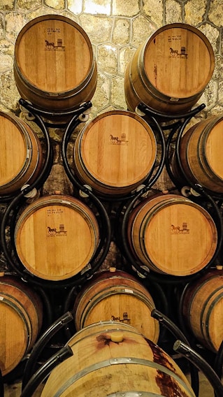 Stainless steel barrels stacked neatly in a warehouse with price tags visible.
