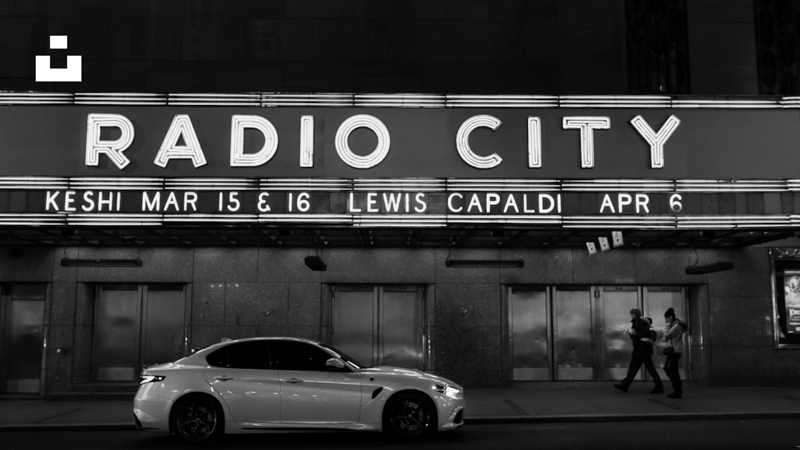 A White Car Parked In Front Of A Radio City Sign Photo Free Ny Image On Unsplash