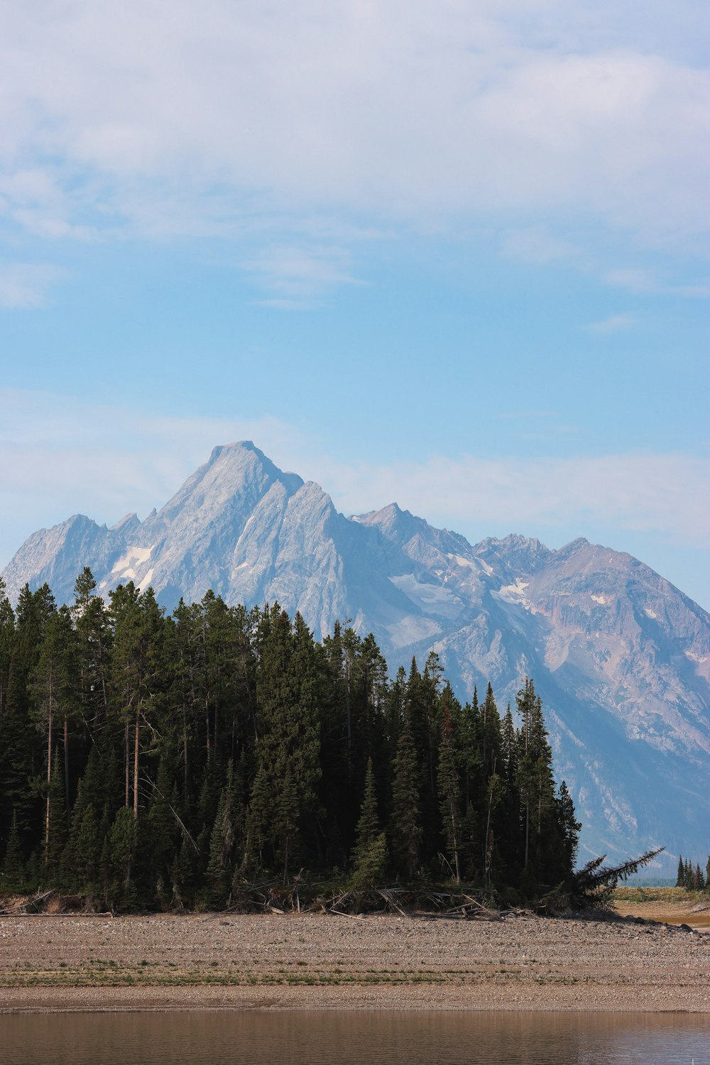 a view of a mountain range with trees in the foreground