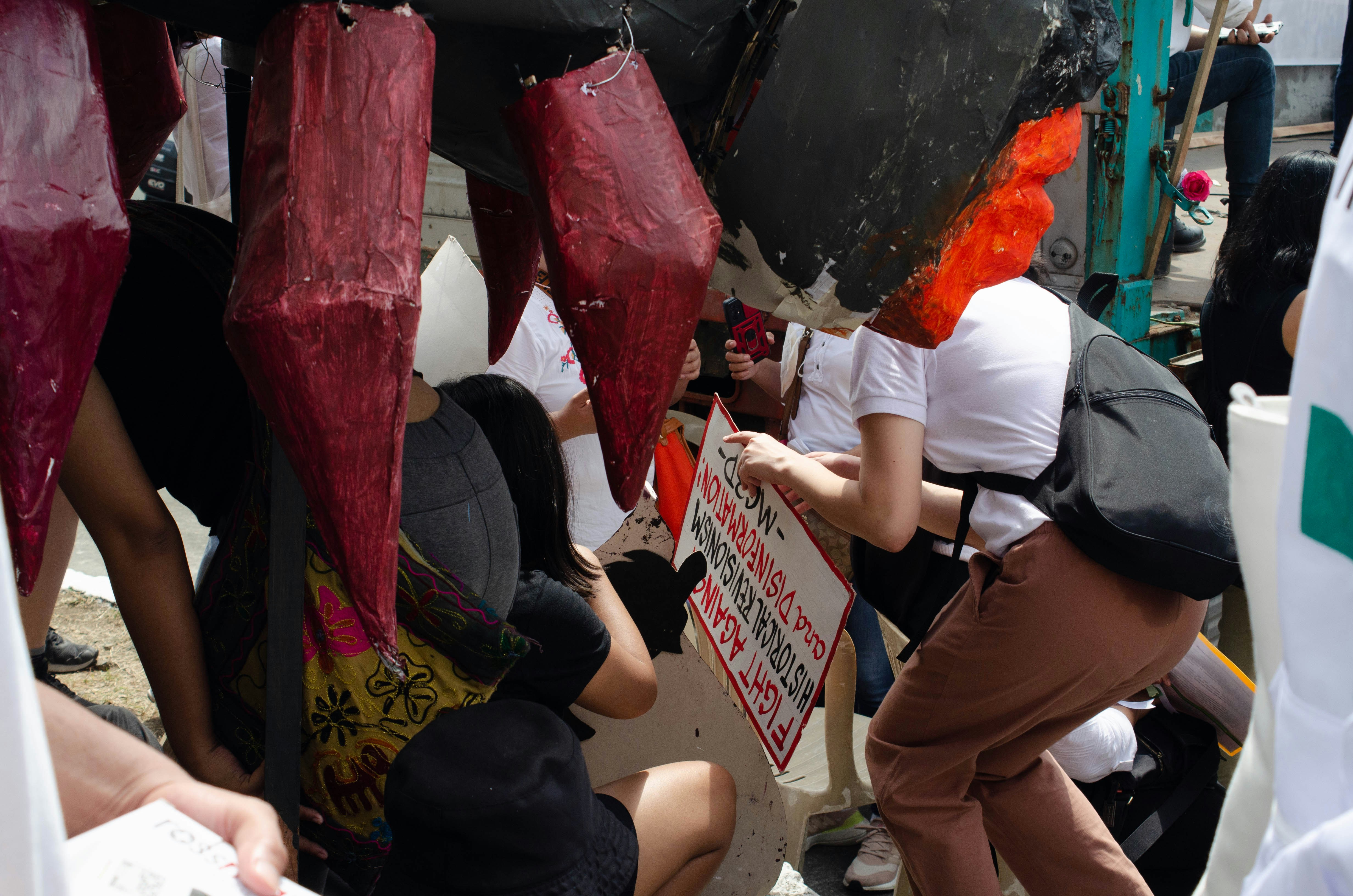 a group of people standing around each other holding signs