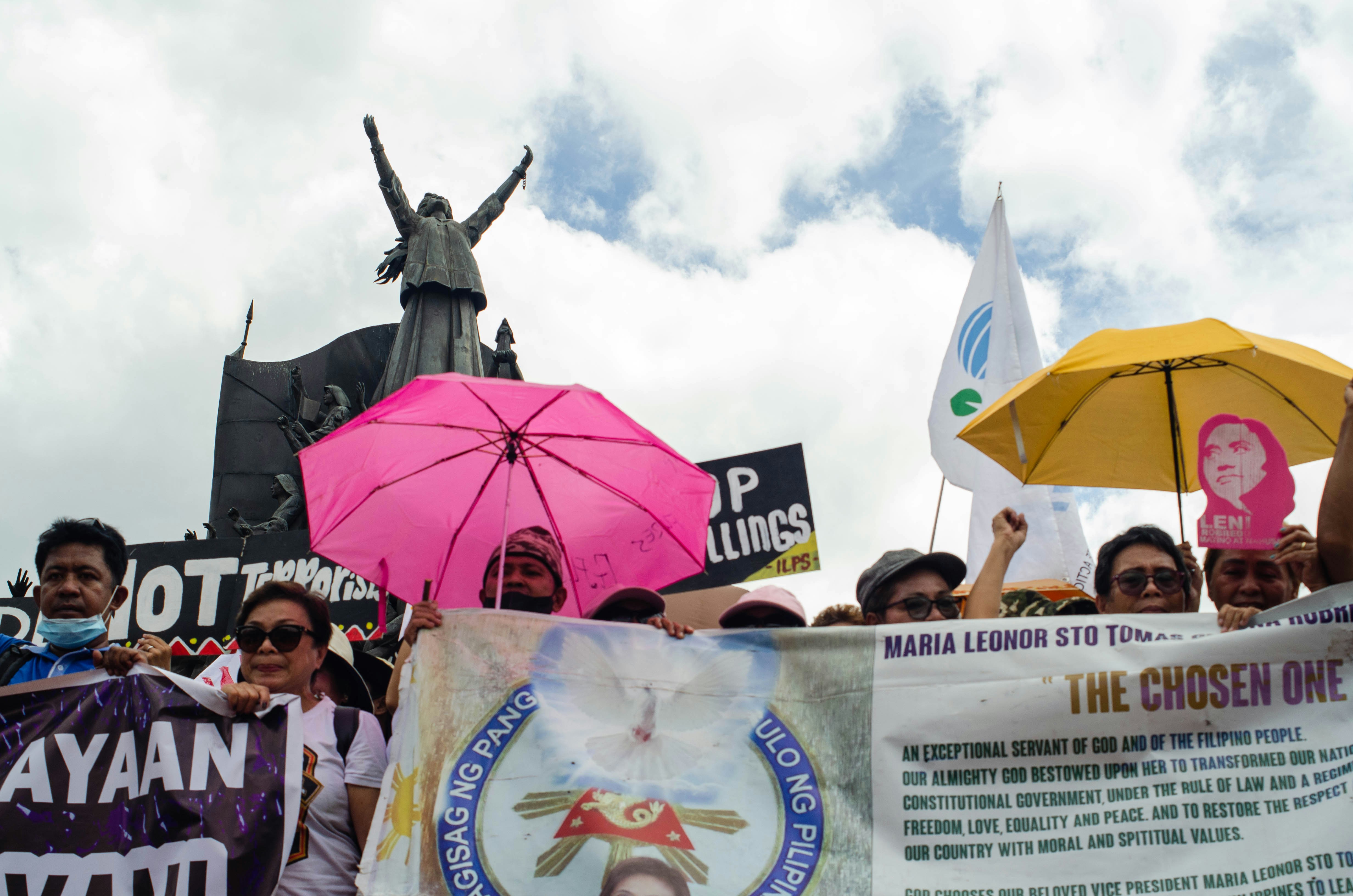 a group of people holding signs and umbrellas