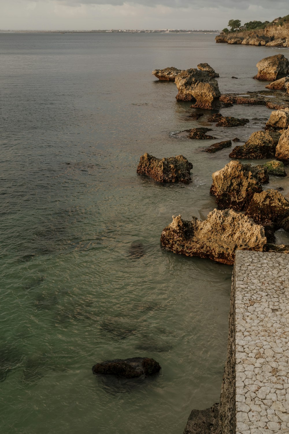 a body of water next to a rocky shore