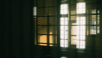 Quiet bedroom with large windows and soft lighting.