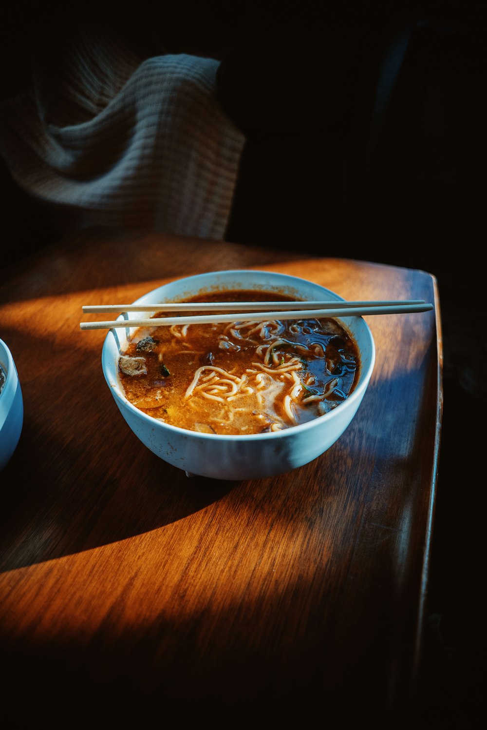 a bowl of soup with chopsticks on a table