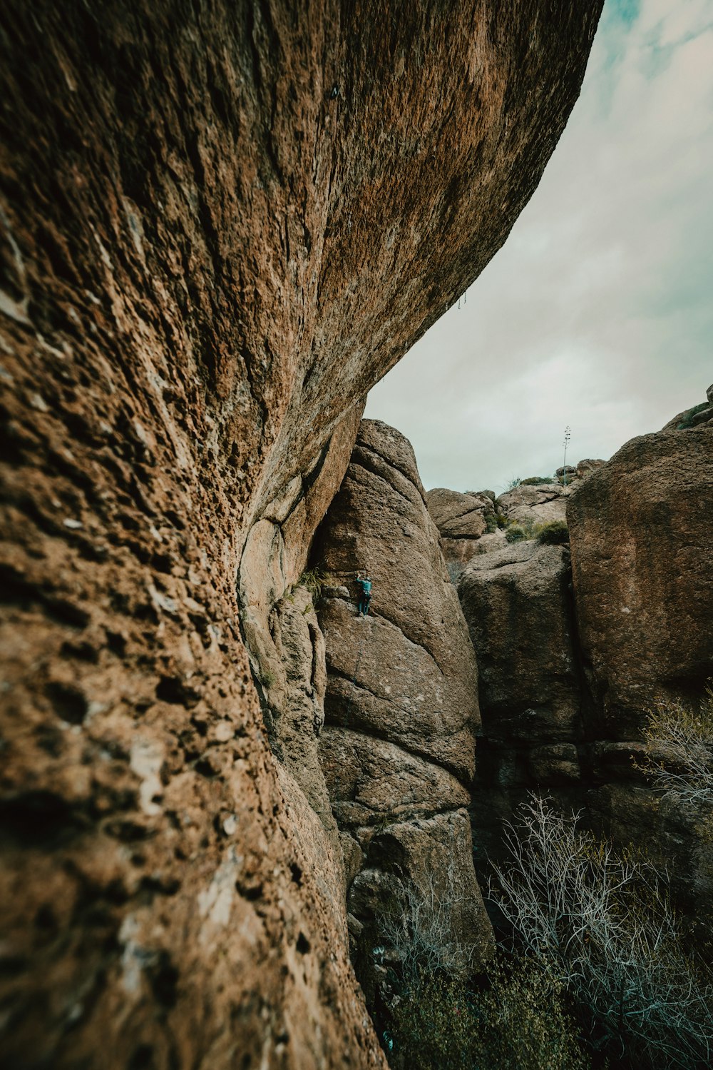 a man climbing up the side of a large rock