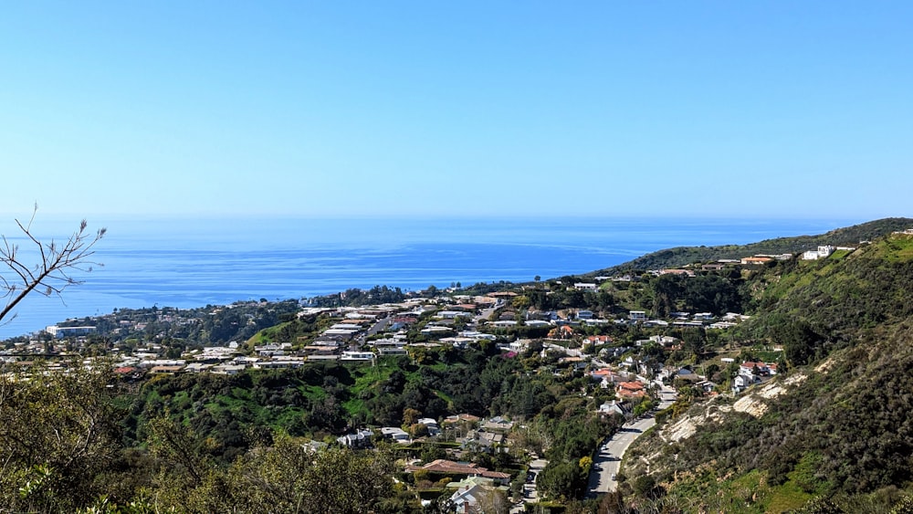 a view of a town on a hill with a body of water in the background