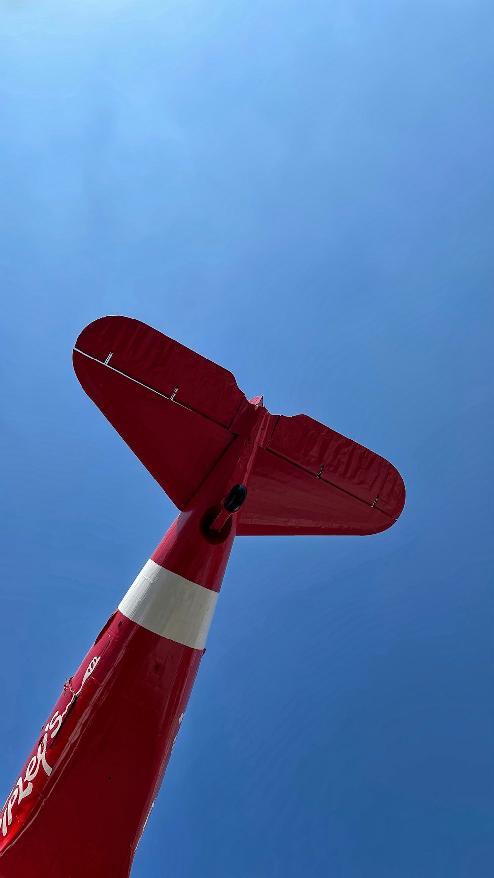 a red airplane is flying in the blue sky