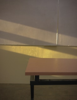 Close-up of an empty wooden table bathed in warm morning light.