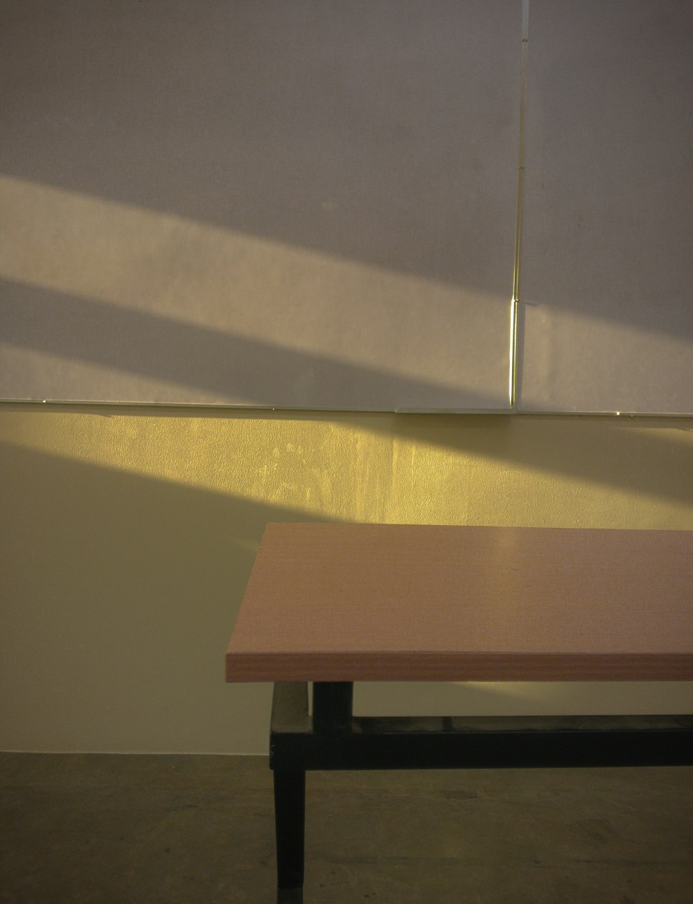 a wooden table sitting in front of a white wall