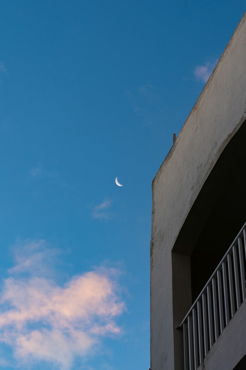 a half moon is seen in the sky above a building