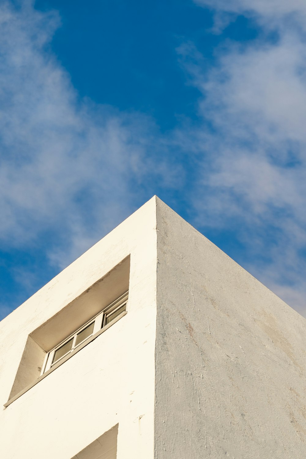 a tall white building with a blue sky in the background