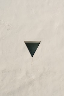 a white wall with a triangle shaped window