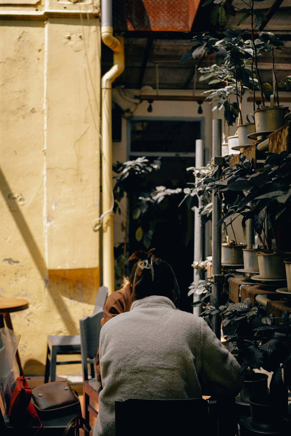 a person sitting in a chair in a room with plants