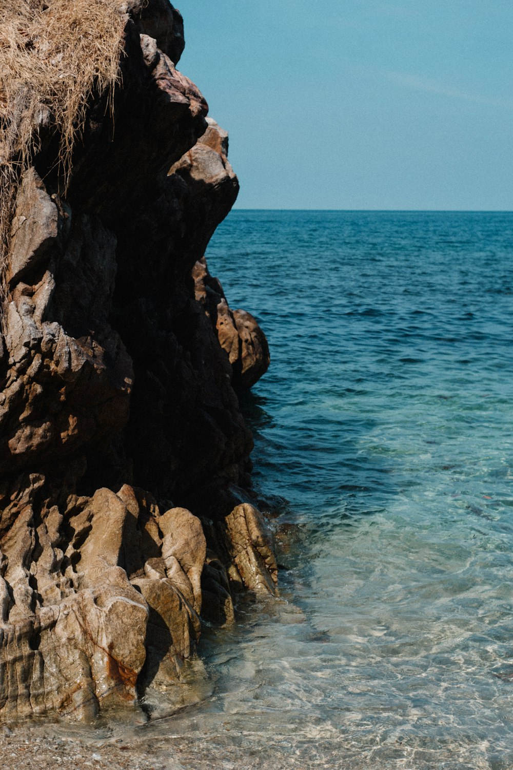 a man standing on a rock next to the ocean