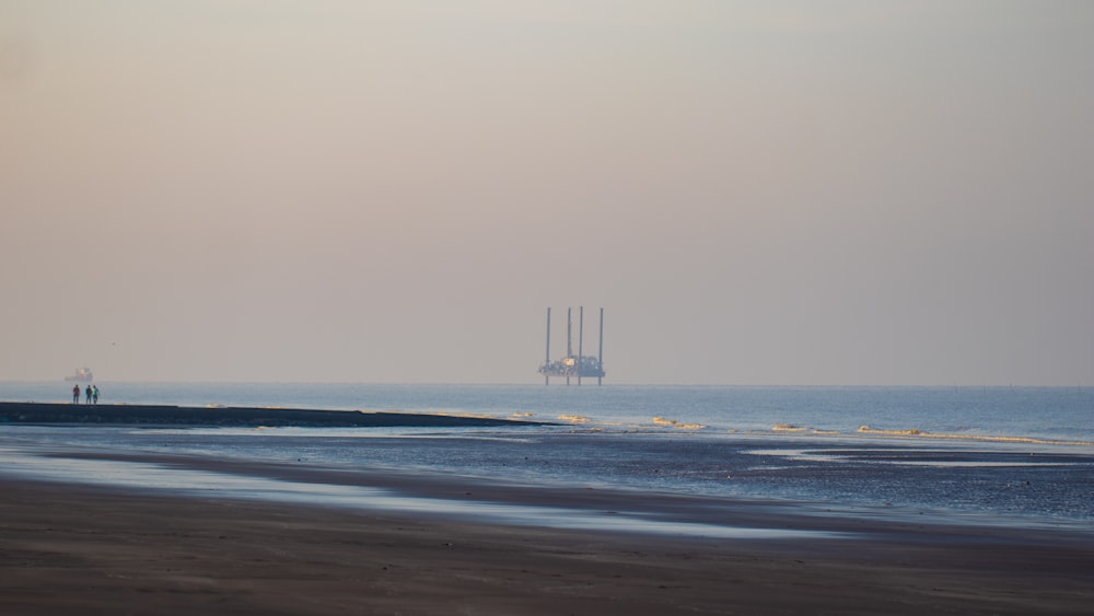 a boat is out in the ocean on a hazy day