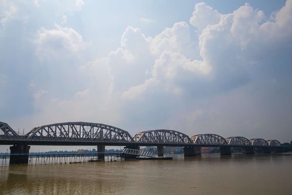 a large bridge spanning over a river under a cloudy sky