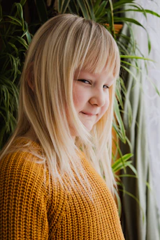 Child in soft beige sweater playing in a cozy, light-filled room