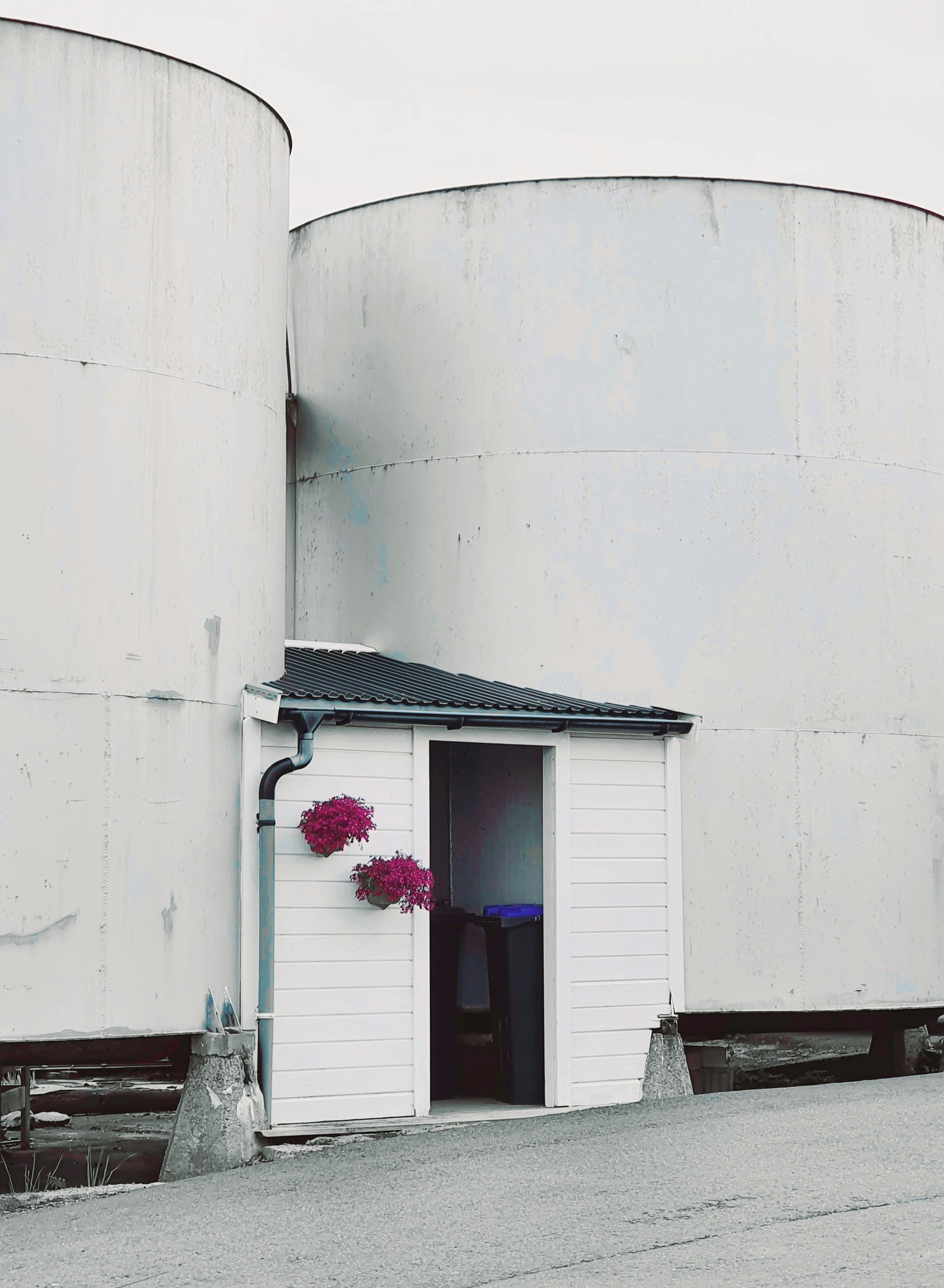 a white building with a black roof and a door