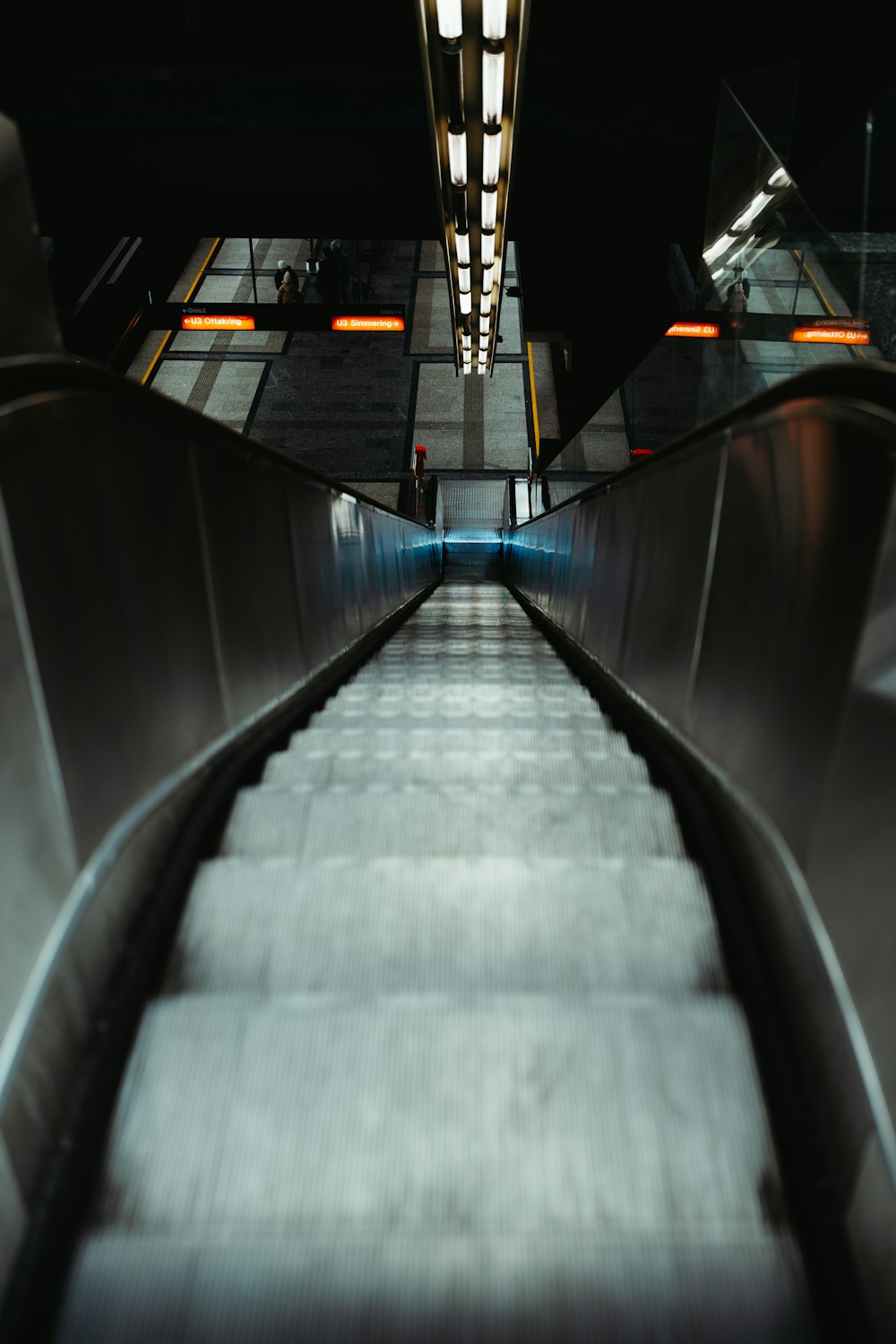uma escada rolante em uma estação de metrô à noite