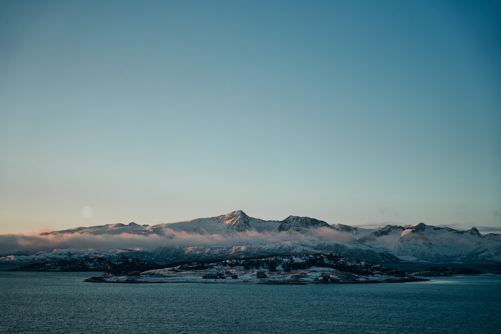 a large body of water with a mountain in the background