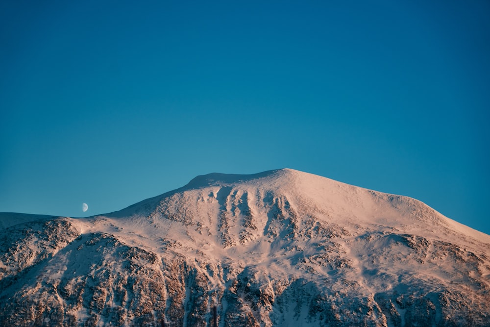 a mountain covered in snow under a blue sky