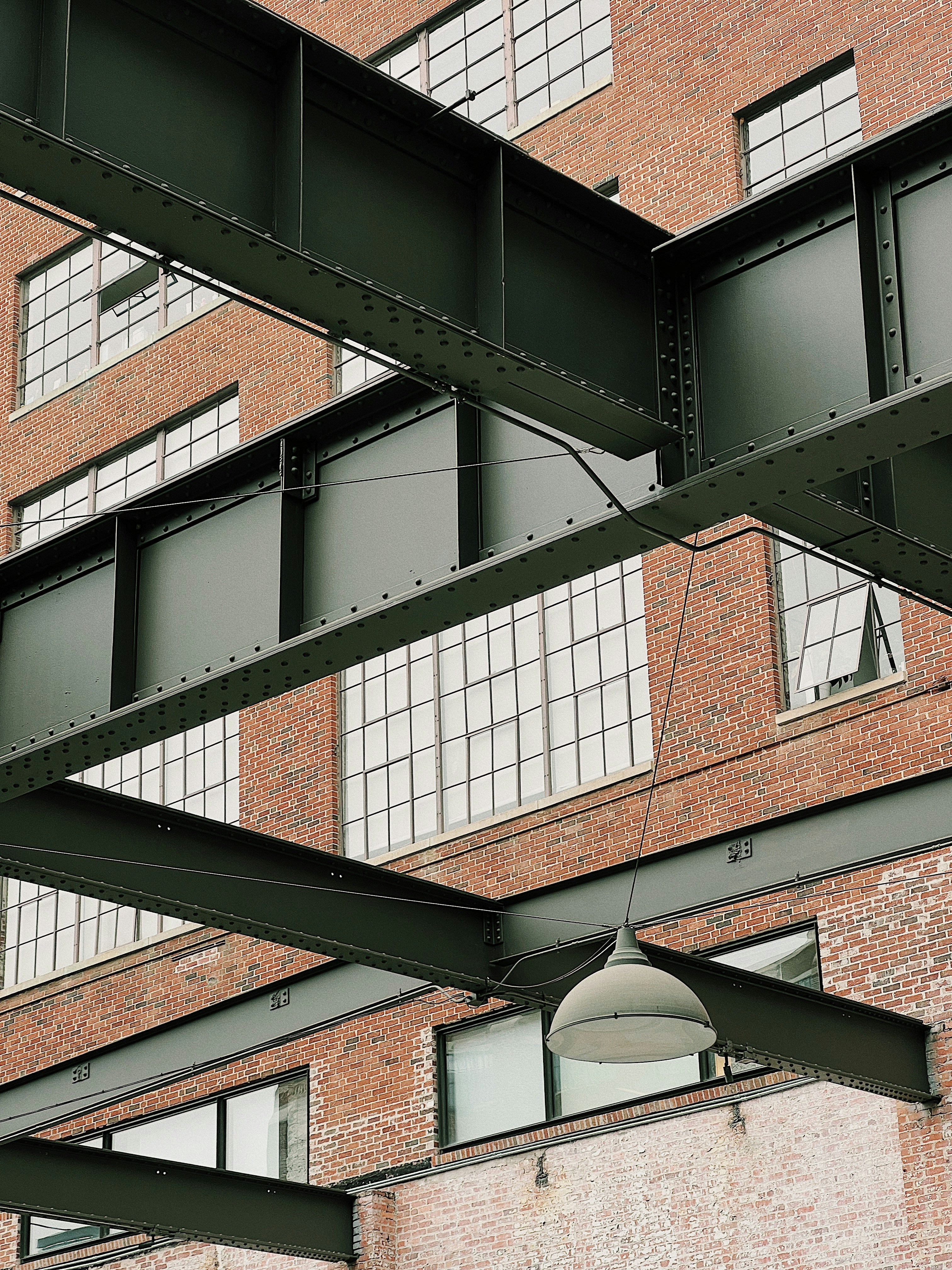 Industrial converted office building with exposed brick, dim warehouse lighting, dark steel beams, moody interior