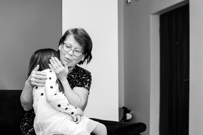 A mentor gently guiding a young girl through a heartfelt conversation in a cozy, colorful room