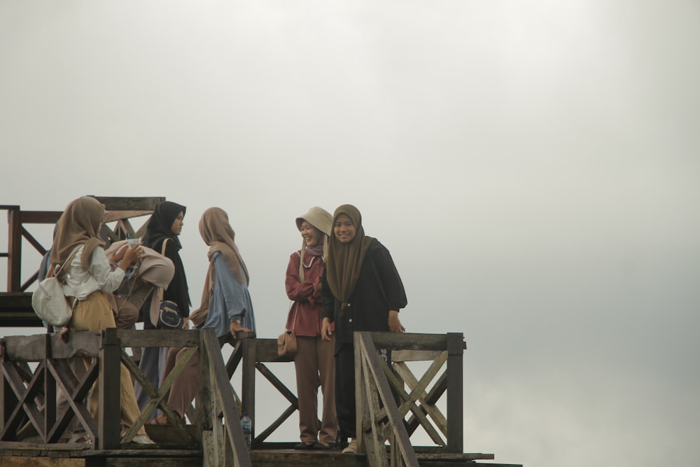 a group of people standing on top of a wooden structure