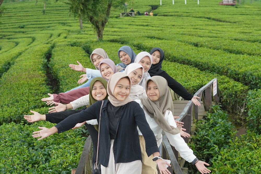 a group of women standing on top of a wooden bridge