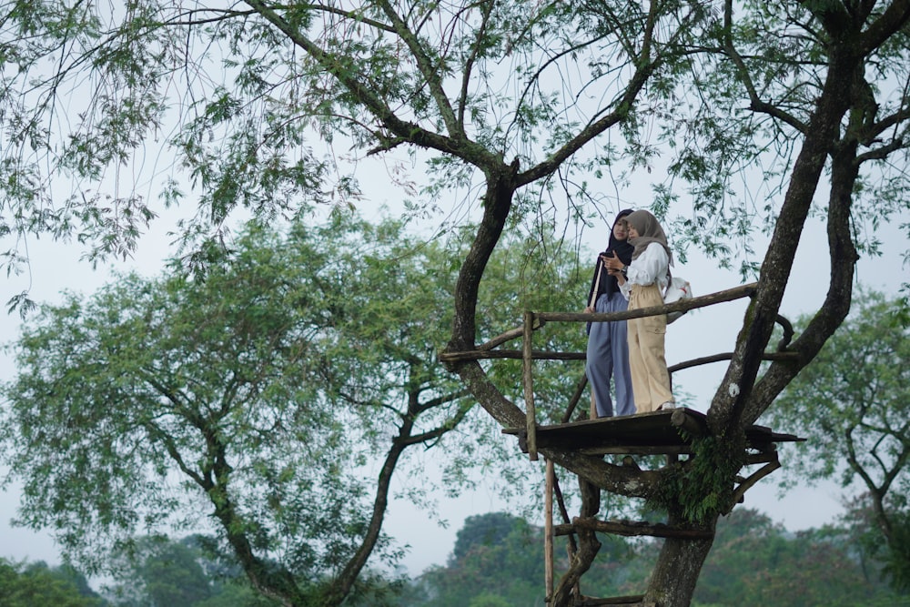 a man and a woman are standing on a ladder