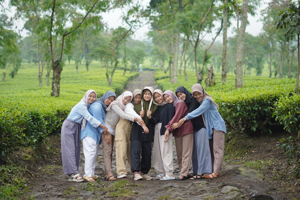 a group of women standing next to each other on a dirt road