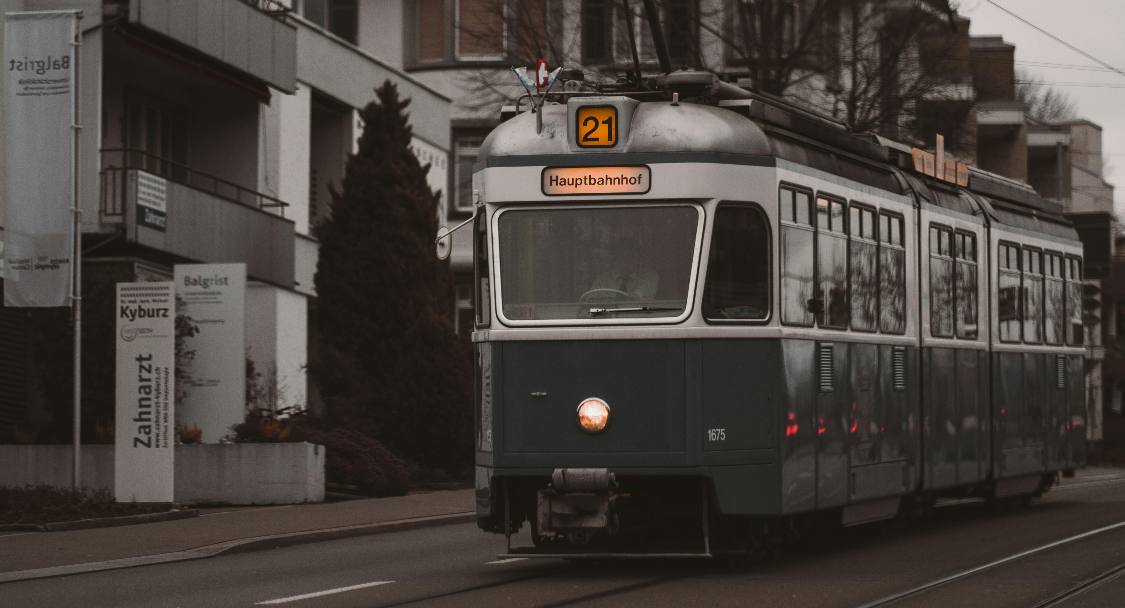 a trolley car traveling down a street next to tall buildings