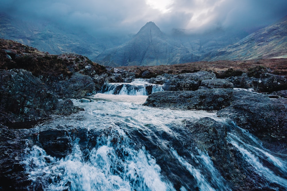 a small waterfall in the middle of a mountain